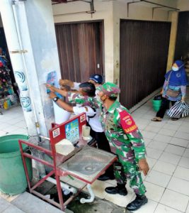 Bersama Security Babinsa Nusukan Pasang Pamflet Pedoman Penanganan Covid 19 di Pasar Tradisional