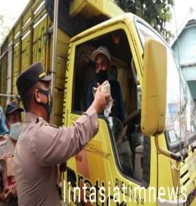 Polres Gresik Bagikan Nasi Bungkus dan Air Mineral Kepada Sopir yang terjebak macet di jalur pantura