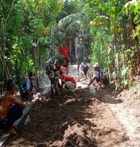 Bangkitkan Semangat Gotong Royong, Babinsa Gandusari Bantu Warga Pasang Paving Jalan
