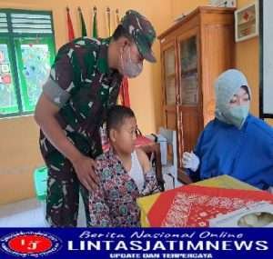 Babinsa Tenangkan Murid Yang Akan Imunisasi