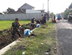 Babinsa Kodim 0802/Ponorogo Kerja Bakti Bersama Warga Desa Binaan Bersihkan Selokan Jalan Desa