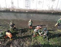 Tanpa Ragu, Babinsa Kestalan Terjun Ke Sungai Bantu Pembersihan Saluran Air