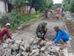 Bersama Warga, Serda Arif Gotong Royong Pasang Paving