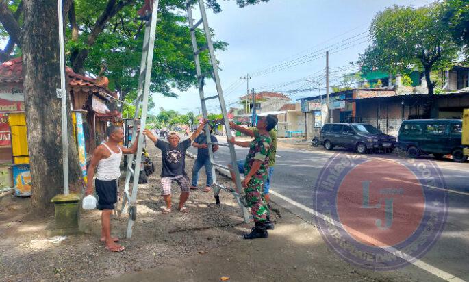 Binter, Anggota Kodim Ponorogo Bantu Warga Perbaiki Lampu Penerangan Jalan