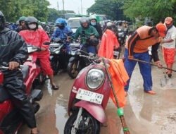 Petugas PPSU Kelurahan Cilincing Bersihkan Lumpur di Jalan Raya Akses Marunda