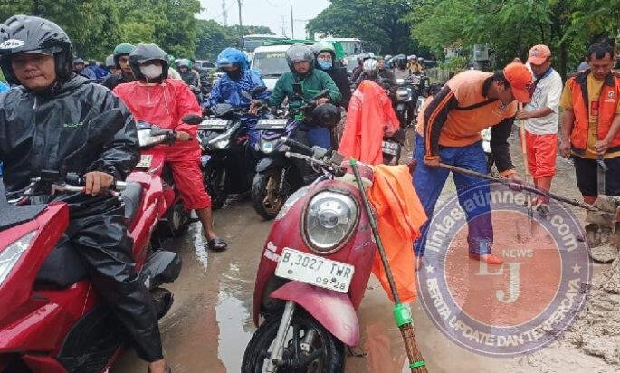 Petugas PPSU Kelurahan Cilincing Bersihkan Lumpur di Jalan Raya Akses Marunda
