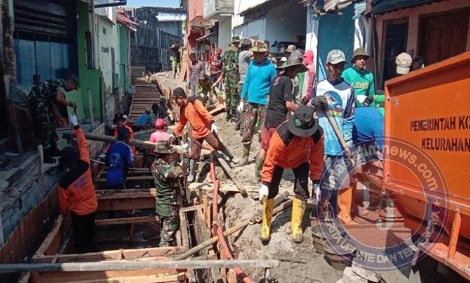 Terik Sinar Matahari Tak Surutkan Satgas TMMD, Ormas dan Warga Dalam Pengecoran Begesteng Kanan Kiri Saluran Air