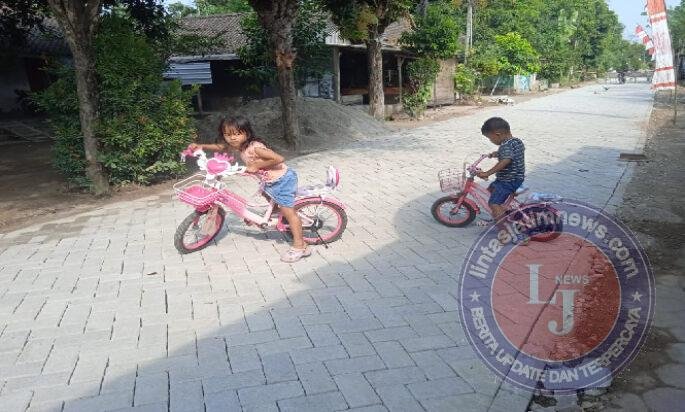 Ekspresi Girang Balita Naik Sepeda Diatas Paving Pembangunan TMMD 129 Bulu Lor